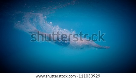 Underwater man dive in a swimming pool.
