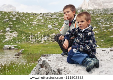 Portrait of two brothers outdoors in the mountains. Dolomites, Italy.