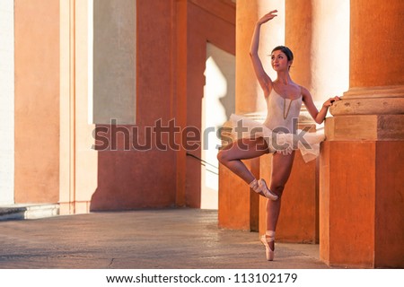 Young beautiful ballerina dancing in front of St. Luca church. Bologna, Italy.