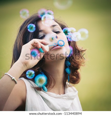 Romantic portrait of young woman with soap balloons.
