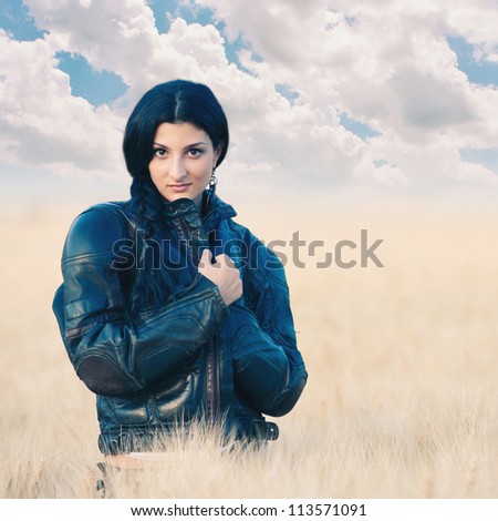 Portrait of beautiful woman with leather jacket in golden wheat
