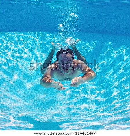 Underwater man in swimming pool.