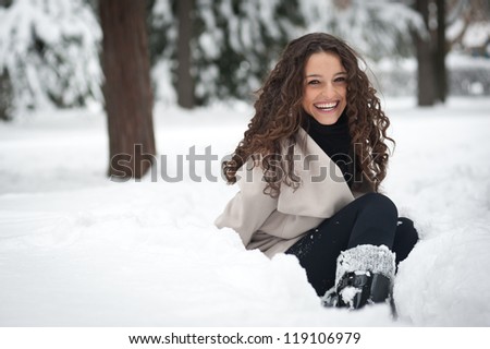 Laughing beautiful girl portrait in winter time with snow.