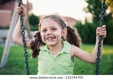 Little girl swinging close up portrait.