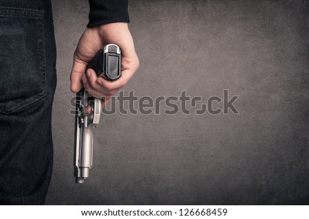 Killer with gun close up over grunge background with copyspace.