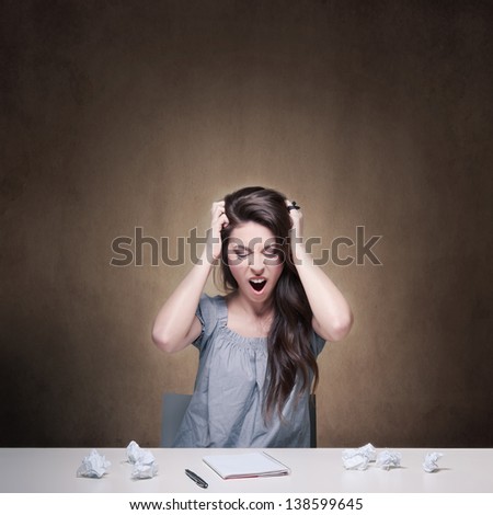 Young desperate girl writing an essay. Conceptual image.