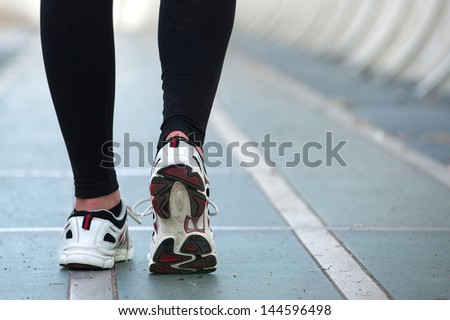 Detail of young woman runner shoes from the back.
