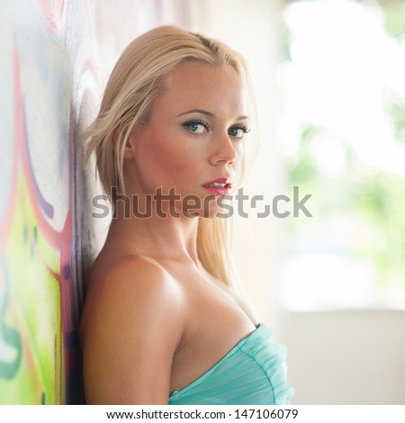 Sensual blonde woman portrait with colorful drawings as background.