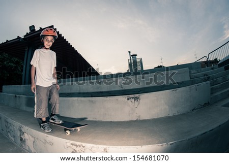Happy boy with skateboard outdoors portrait.