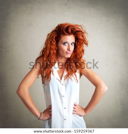 Funny redhead woman portrait against grunge background.
