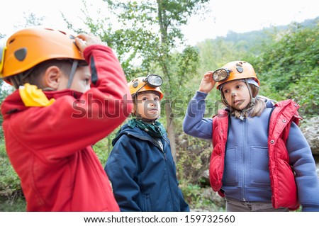 Group of young kids wearing helmet for cave exploration.
