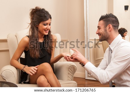 Young man making a marriage proposal to his girlfriend in a hotel.