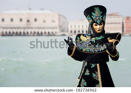 Carnival of Venice, beautiful mask at St. George island with Mark\'s Square in the background.