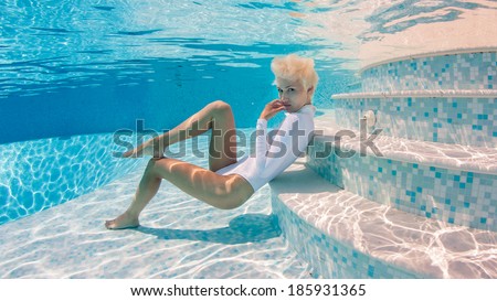 Woman wearing swimsuit underwater in swimming pool.