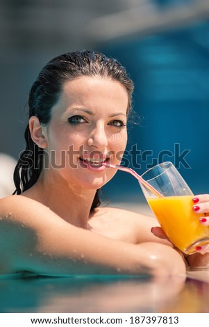 Young woman portrait relaxing and having a drink in a swimming pool in Dubai. Filtered image.