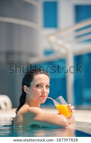 Young woman portrait relaxing and having a drink in a swimming pool in Dubai. Filtered image.