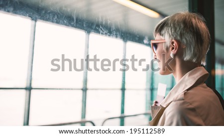 Businesswoman at airport looking at window.