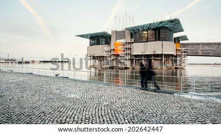 LISBON, PORTUGAL - JANUARY 4, 2014: People walking in front of Lisbon Oceanarium at sunset. Located in the Park of the Nations in the Expo area of Lisbon, it is the largest indoor aquarium in Europe.