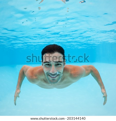 Smiling underwater man portrait inside swimming pool.