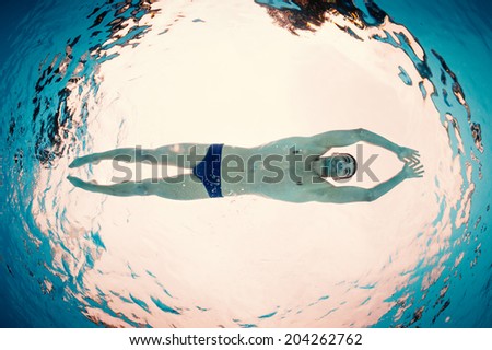 Underwater man inside swimming pool from below. Full body.