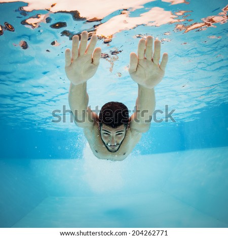 Underwater man inside swimming pool after dipping.
