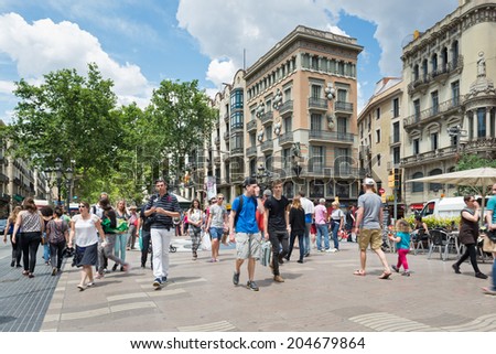 BARCELONA, SPAIN - MAY 31, 2014: Tourists walking along the famous Rambla street. Barcelona is the 15th most visited city worldwide (8.8m in 2013).