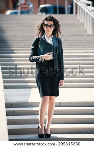 Business woman outdoors walking on the stairs. Full body portrait.