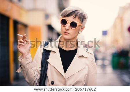 Young woman portrait with cigarette walking in Paris, France.