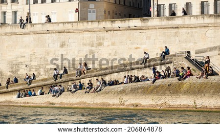 PARIS, FRANCE - MAY 16, 2014: People relax on the river Seine at sunset.