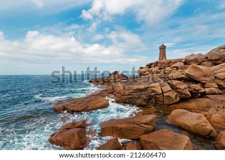 Ploumanac\'h lighthouse against blue cloudy sky. It is an active lighthouse in Cotes-d\'Armor, France, located in Perros-Guirec. The structure is composed of pink granite.
