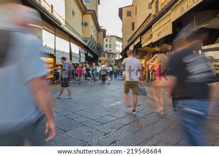 FLORENCE, ITALY - SEPTEMBER 17, 2014: People walking on Ponte Vecchio (Old Bridge). Ponte Vecchio is a medieval bridge, one of the most famous and popular tourist attractions in Florence.