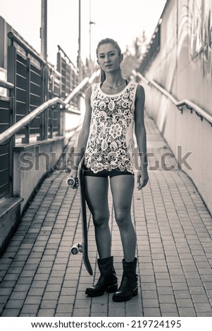 Teenager with skateboard full body portrait. Black and white image.