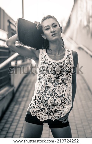 Teenager with skateboard portrait. Black and white image.