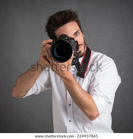 Man with camera portrait over dark grunge background.