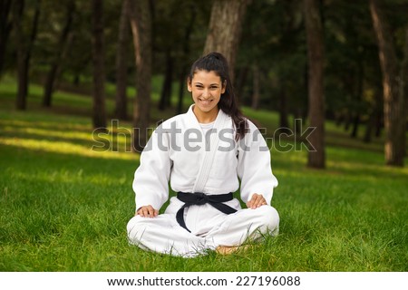 Young woman practicing judo portrait outdoors in a park.