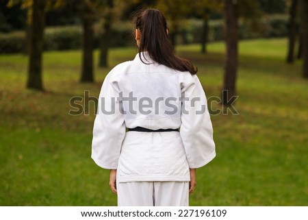 Young woman practicing judo back portrait outdoors in a park.