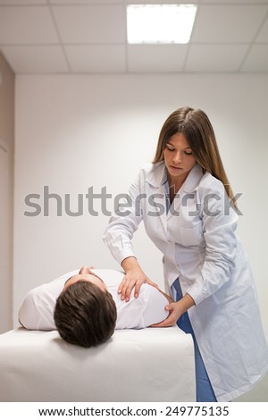 Female doctor physiotherapist practicing massage to her male patient in medical center.