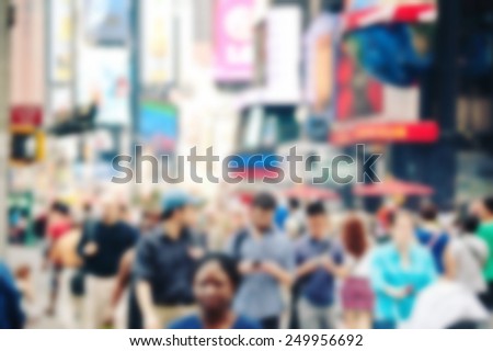 People crossing the street in Times Square, New York. Blurred and filtered image with unrecognizable people.