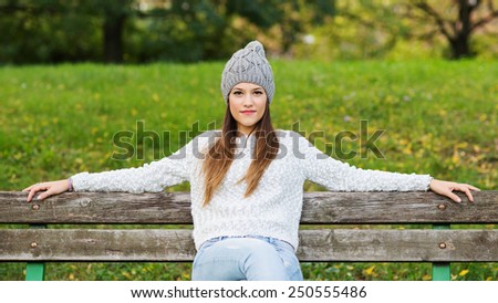 Beautiful young woman close up portrait with natural green background relaxing in a park.