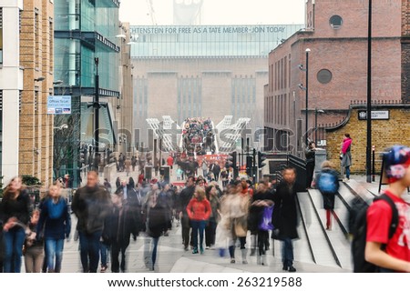 LONDON - APRIL 11, 2013: People walking over Millennium bridge. It\'s a suspension bridge with a total length of 370 metres (1,214 ft) and a width of 4 metres (13 ft).