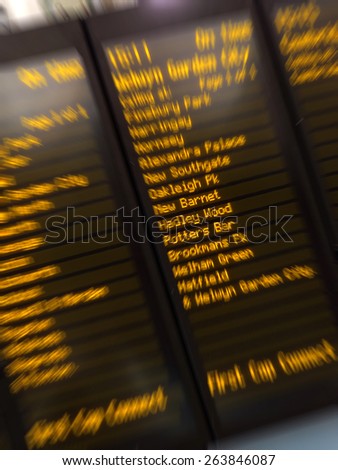 Departure and arrivals terminal stations shown on digital display at Underground station in London. Travel lifestyle concept. Radial zoom effect defocused.