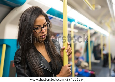 Young mixed race businesswoman portrait inside underground wagon in London.