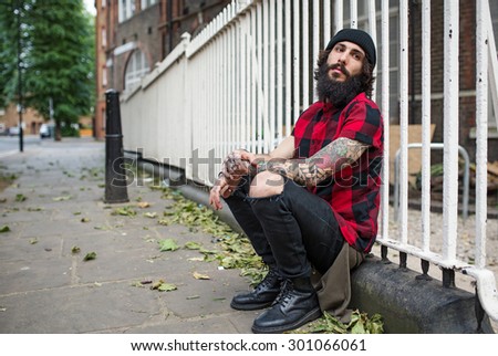 Young tattooed man intimate portrait in Shoreditch borough. London, UK. Hipster style.