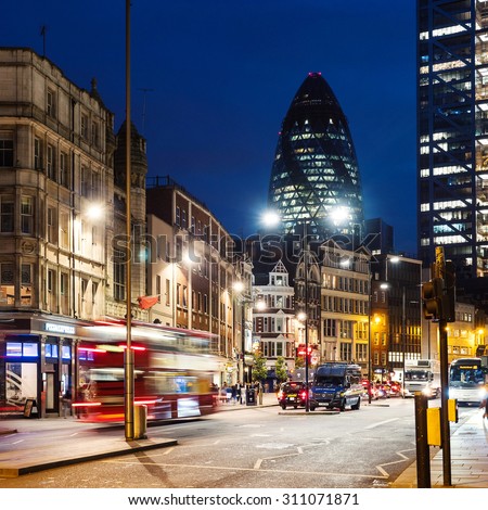 LONDON, UK - CIRCA JUNE 2015: Traffic and Gherkin building in the background at night. The Gherkin has become an iconic symbol of London.