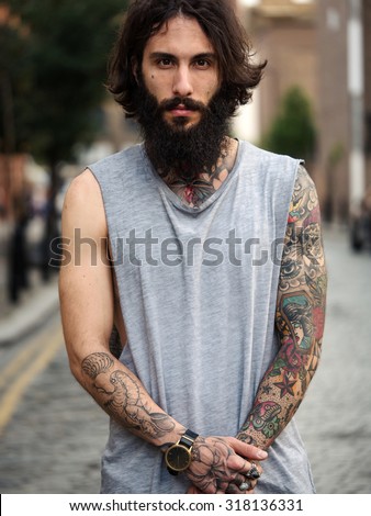 Intense portrait of young tattooed man on the street in Shoreditch borough. London, UK. Hipster style