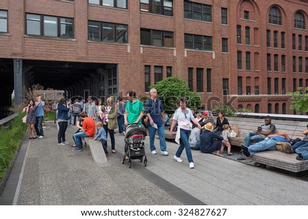 NEW YORK CITY - MAY 16, 2015: People walking on the High Line Park. The High Line is a park built on an historic freight rail line elevated above the streets in the West Side.