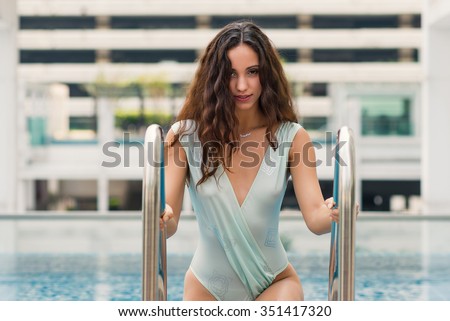 Sensual woman portrait wearing swimsuit in swimming pool in Bangkok, Thailand. Filtered image.