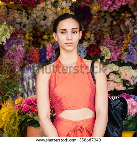 Beautiful young woman portrait in front of traditional flowers market in Bangkok, Thailand.