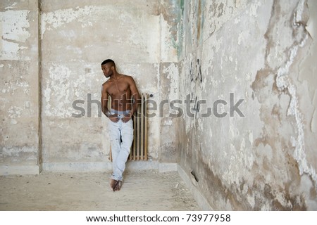Black muscular man intense portrait, indoor. Inside abandoned building.