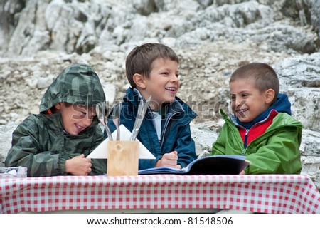 Kids having fun during lunch in a mountain refuge. Dolomites, Italy.